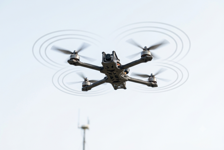 Modern counter-drone detection tower with radar panel, EO IR camera gimbal, and acoustic microphone array.